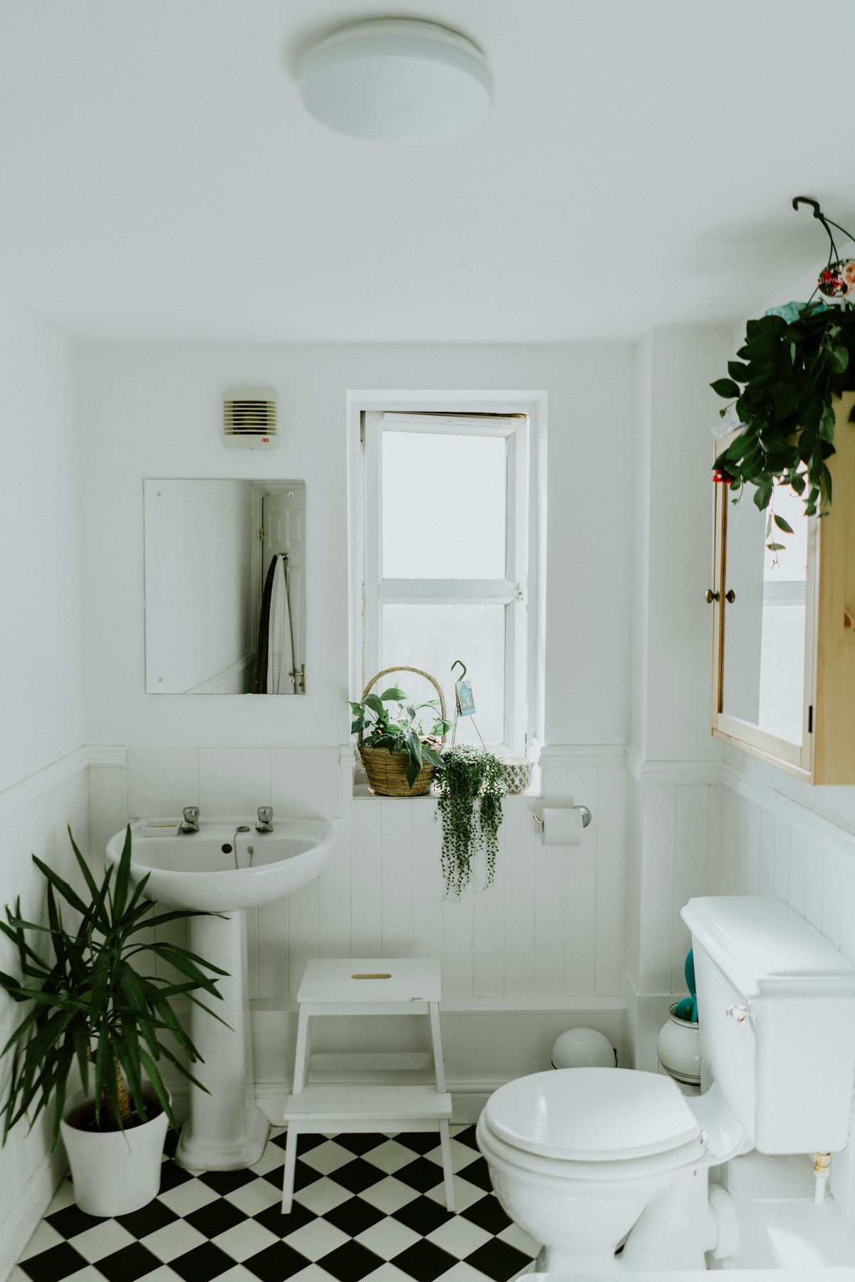 Renovated white bathroom with checkerboard floor